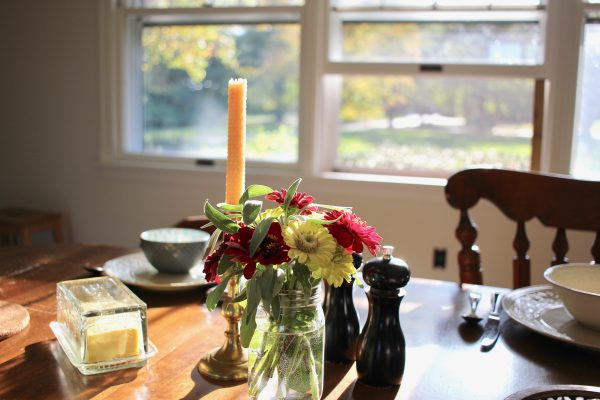 setting dinner table with flowers, candle, cloth napkin, nice dishes can make dinner more intentional