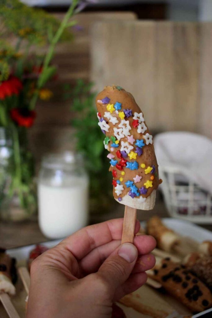 close up of banana popsicle with natural colored and flavored star sprinkles. 
