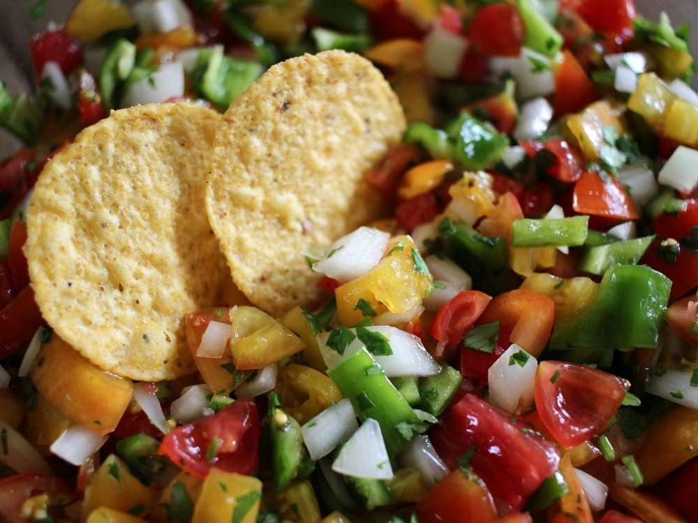 A close up pictures of corn chips and homemade garden fresh tomato salsa. 