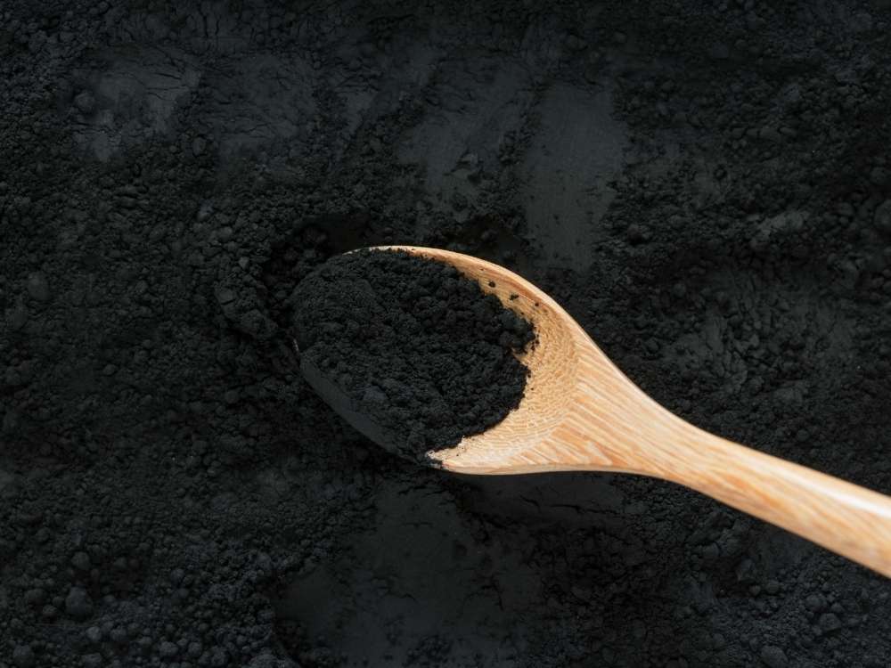 A wooden spoon with activated charcoal.