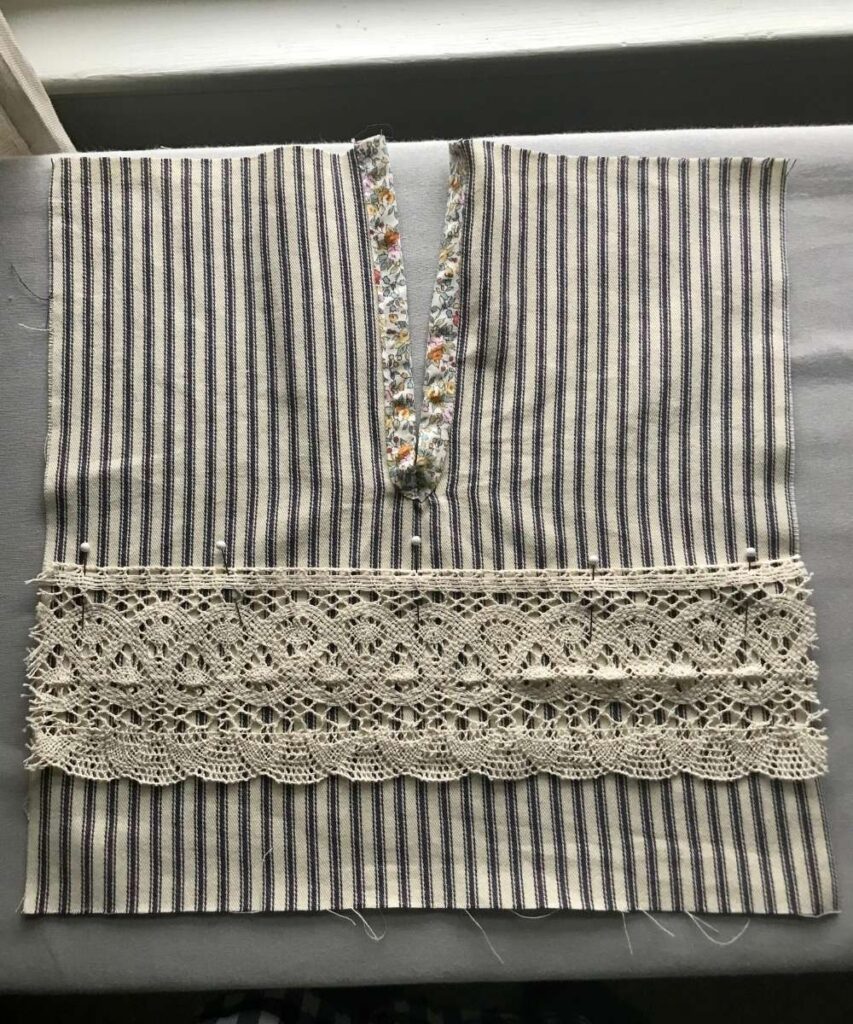 A picture of the front of the simple clothespin bag showing how to attach the crocheted lace with pins.