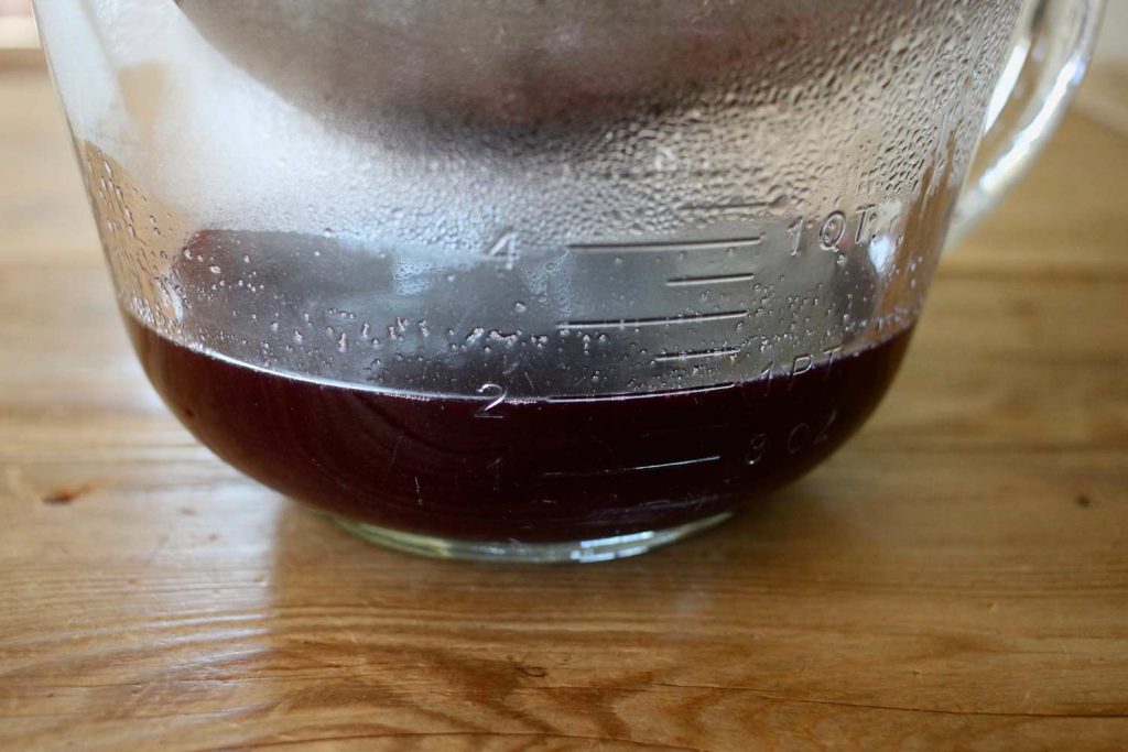 strained elderberry liquid in a measuring bowl
