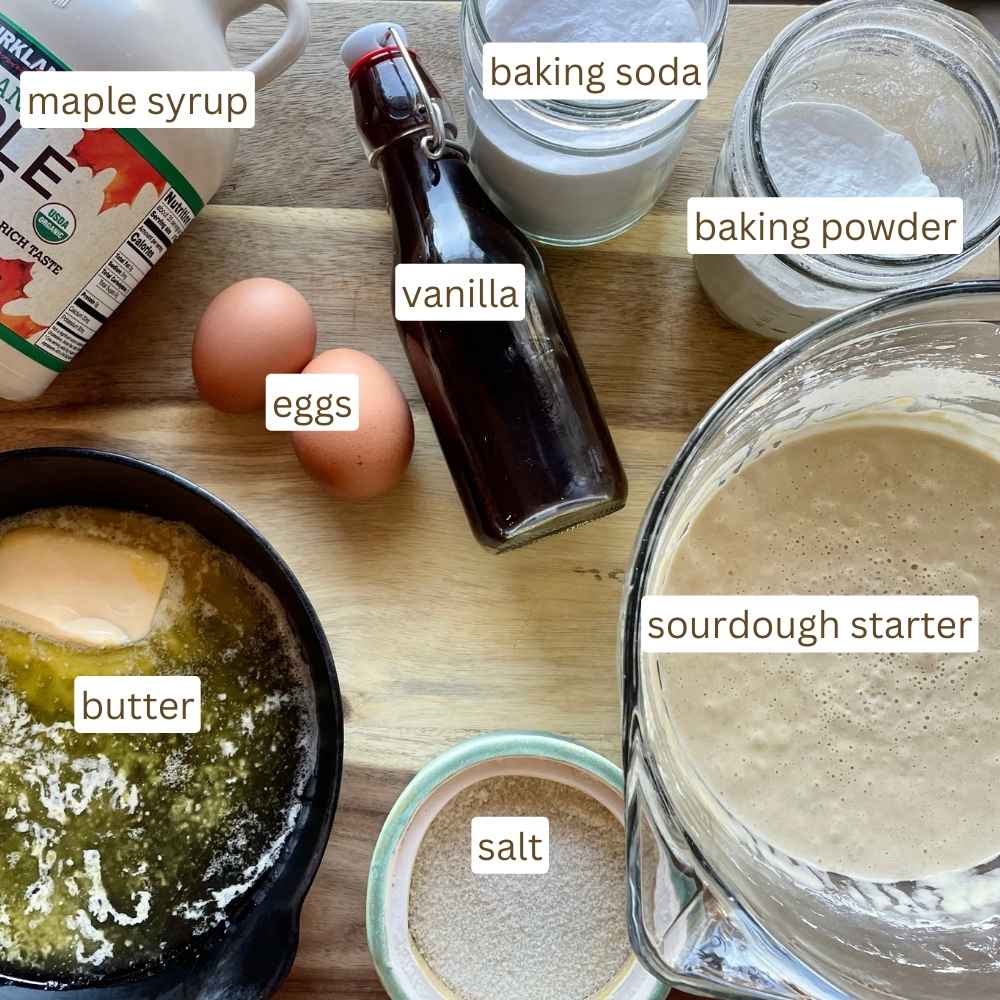 Ingredients for sourdough waffles: maple syrup, eggs, vanilla, baking powder, baking soda, butter, salt, sourdough starter.